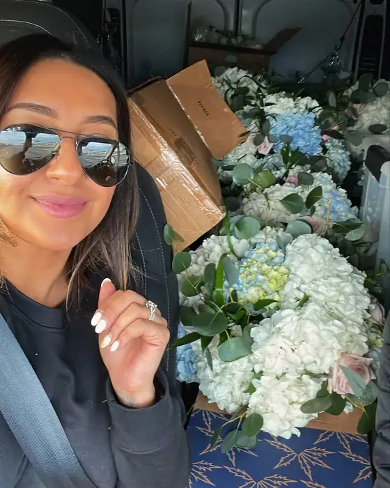 Mani of Eden Events & Co. in the studio van loaded with fresh white and blue hydrangea arrangements for delivery
