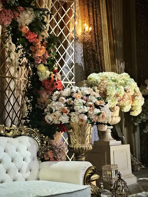 Gold baroque sofa with blush peony and hydrangea urns, gold lattice and sequin drapes
